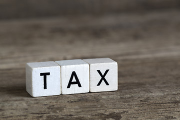 Image showing Tax, written in cubes on wooden background