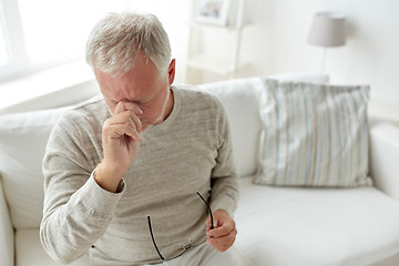 Image showing senior man suffering from headache at home