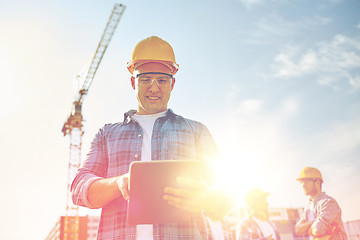 Image showing builder in hardhat with tablet pc at construction