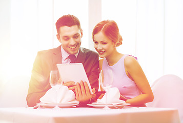 Image showing couple with menus on tablet pc at restaurant