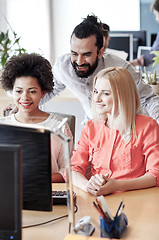 Image showing happy creative team with computer in office