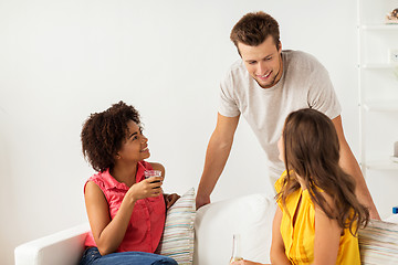 Image showing group of happy friends with drinks talking at home