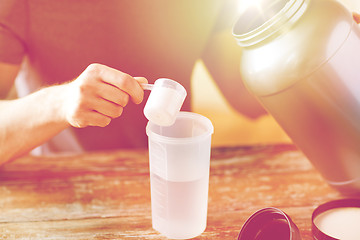 Image showing close up of man with protein shake bottle and jar