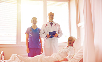 Image showing doctor and nurse visiting senior woman at hospital