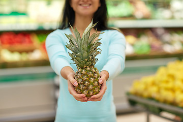 Image showing woman with pineapple at grocery store
