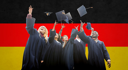 Image showing happy students throwing mortarboards up