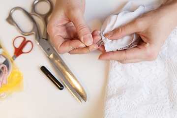 Image showing Girl unpick fabric on table