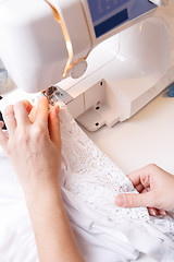 Image showing Woman scribbles fabric on sewing-machine