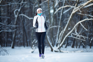 Image showing Sportswoman running in winter park