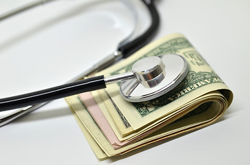 Image showing Stethoscope sitting on US dollar bills