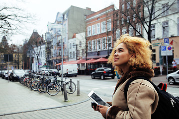 Image showing young pretty african american girl with curly hair making photo on a tablet, lifestyle people concept, tourist in european german city