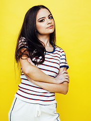 Image showing young pretty teenage woman emotional posing on yellow background, fashion lifestyle people concept 