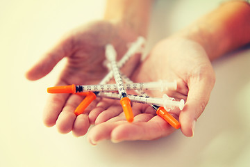 Image showing close up of woman hands holding insulin syringes