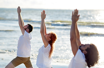 Image showing group of people making yoga exercises on beach