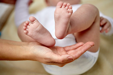 Image showing close up of newborn baby feet in mother hands