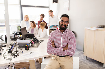 Image showing happy indian man over creative team in office
