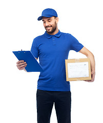 Image showing happy delivery man with parcel box and clipboard