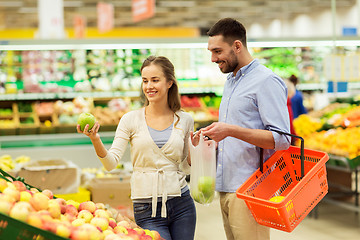 Image showing happy couple buying apples at grocery store