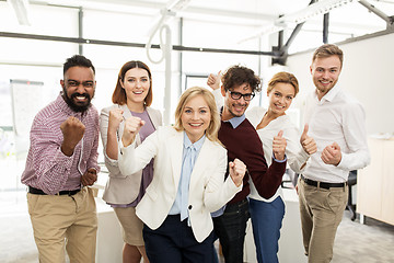 Image showing happy business team celebrating victory at office