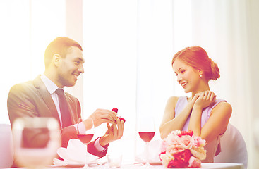 Image showing man proposing to his girlfriend at restaurant