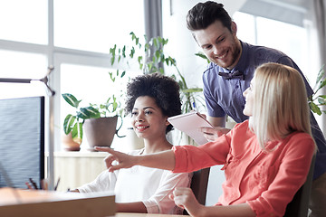 Image showing happy creative team with computer in office