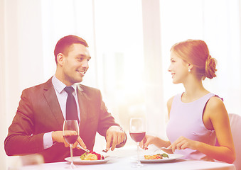 Image showing smiling couple eating main course at restaurant