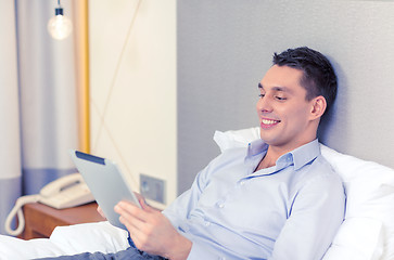 Image showing happy businesswoman with tablet pc in hotel room