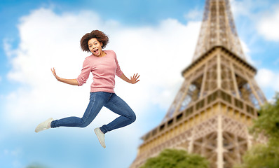 Image showing happy african american woman jumping over white