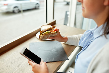 Image showing woman with smartphone and sandwich at restaurant