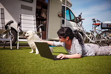 Image showing Woman on the grass with a dog looking at a laptop