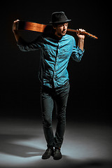 Image showing Cool guy standing with guitar on dark background