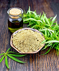 Image showing Flour hemp in bowl with oil and leaf on board