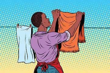 Image showing Vintage employee hangs up to dry clothes