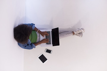 Image showing african american woman sitting on floor with laptop top view