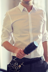 Image showing close up of male stylist with brush at salon