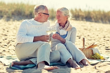 Image showing happy senior couple having picnic on summer beach