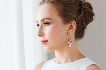 Image showing smiling woman in white dress with pearl jewelry