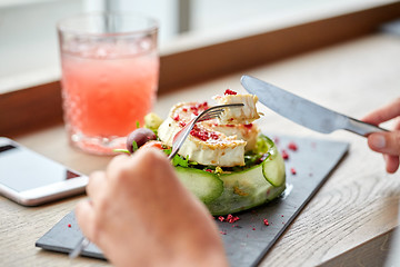 Image showing woman eating goat cheese salad at restaurant