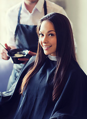 Image showing happy young woman coloring hair at salon