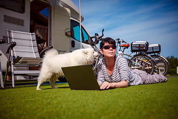 Image showing Woman on the grass with a dog looking at a laptop