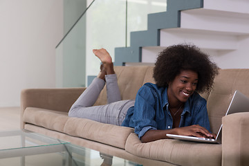 Image showing African American woman using laptop on sofa