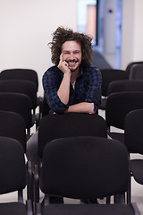 Image showing A student sits alone  in a classroom