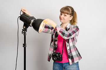 Image showing Photographer studio sets reflector on monoblock flash