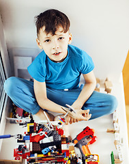 Image showing little cute preschooler boy playing lego toys at home happy smil