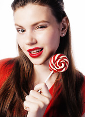 Image showing young pretty brunette girl with red candy posing on white background isolated 