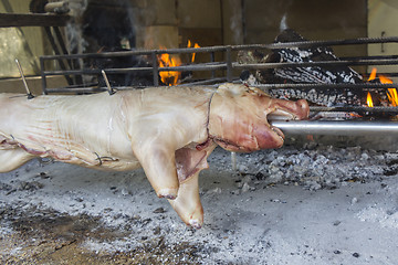 Image showing Roasting suckling pig on the broach in the coals