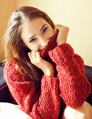 Image showing young pretty real woman in sweater and scarf all over her face smiling