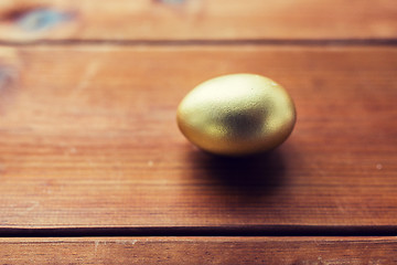 Image showing close up of golden easter egg on wood