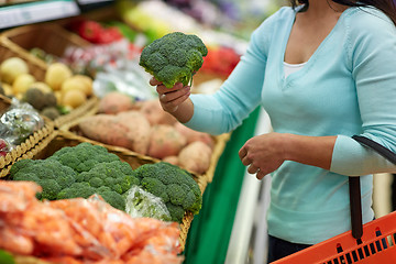 Image showing woman with basket buying broccoli at grocery store