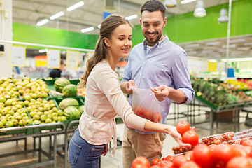 Image showing happy couple buying tomatoes at grocery store